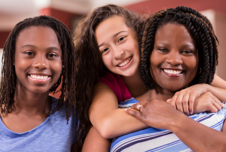 Three young girls embracing happily