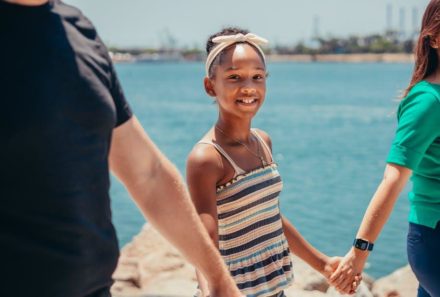 adoptive family holding hands on beach