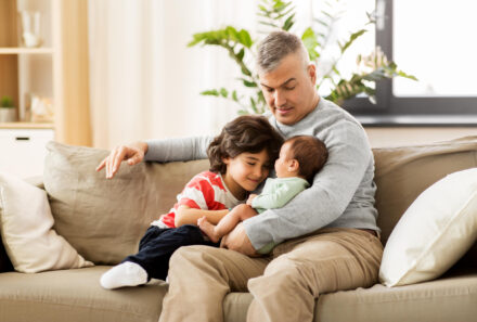 Father holding adopted siblings